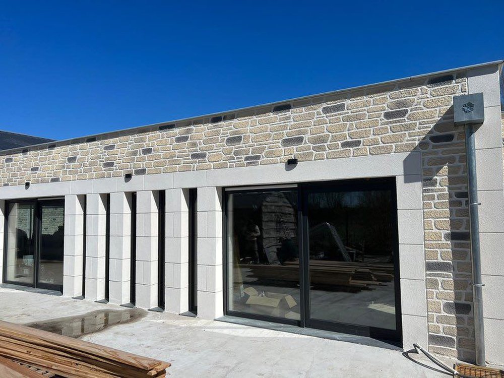Extension moderne en pierre et baies vitrées réalisée par G2O Habitat